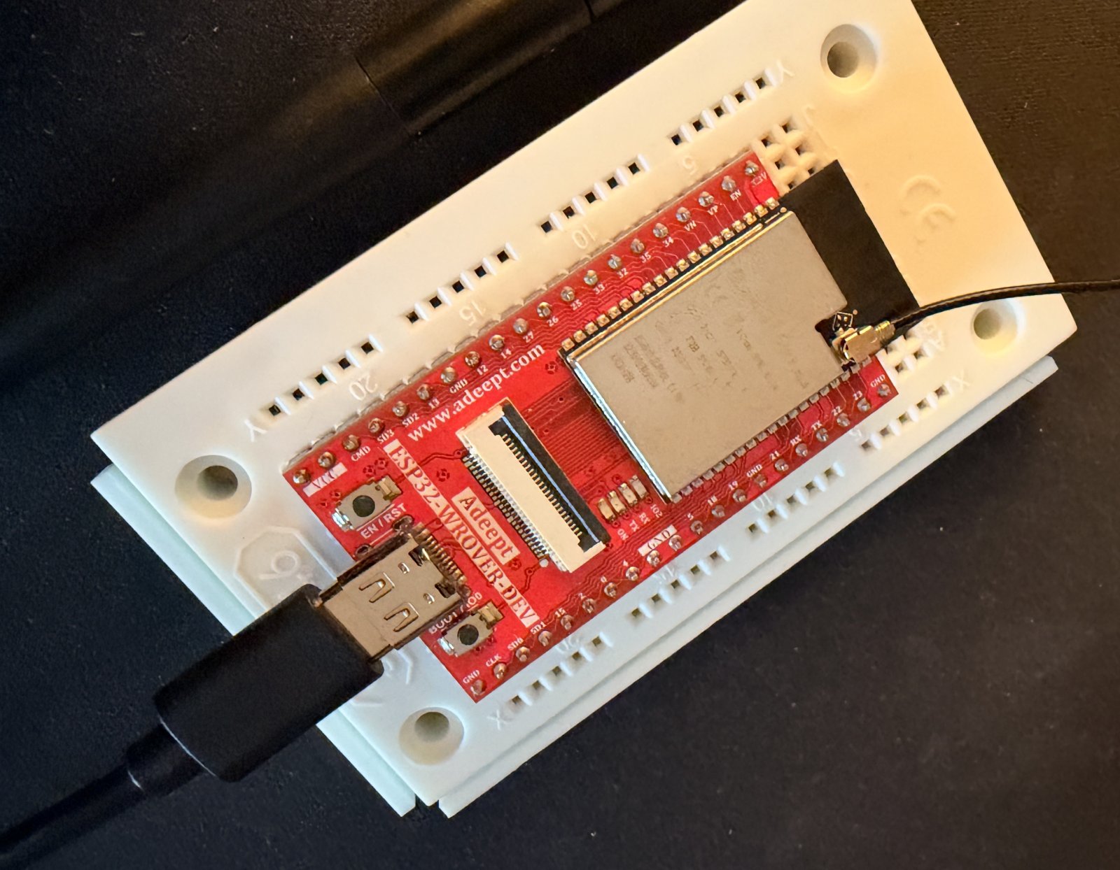 Nahaufnahme des roten Adeept-ESP32-WROVER-DEV-Boards mit Metallmodul, Antennenkabel und USB-C-Kabel